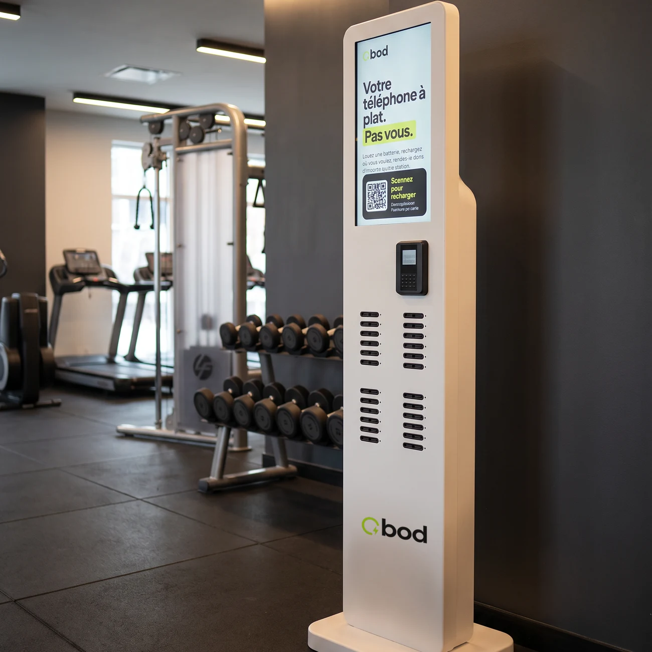 Borne BOD sur pied dans une salle de sport, devant les haltères et les tapis de course